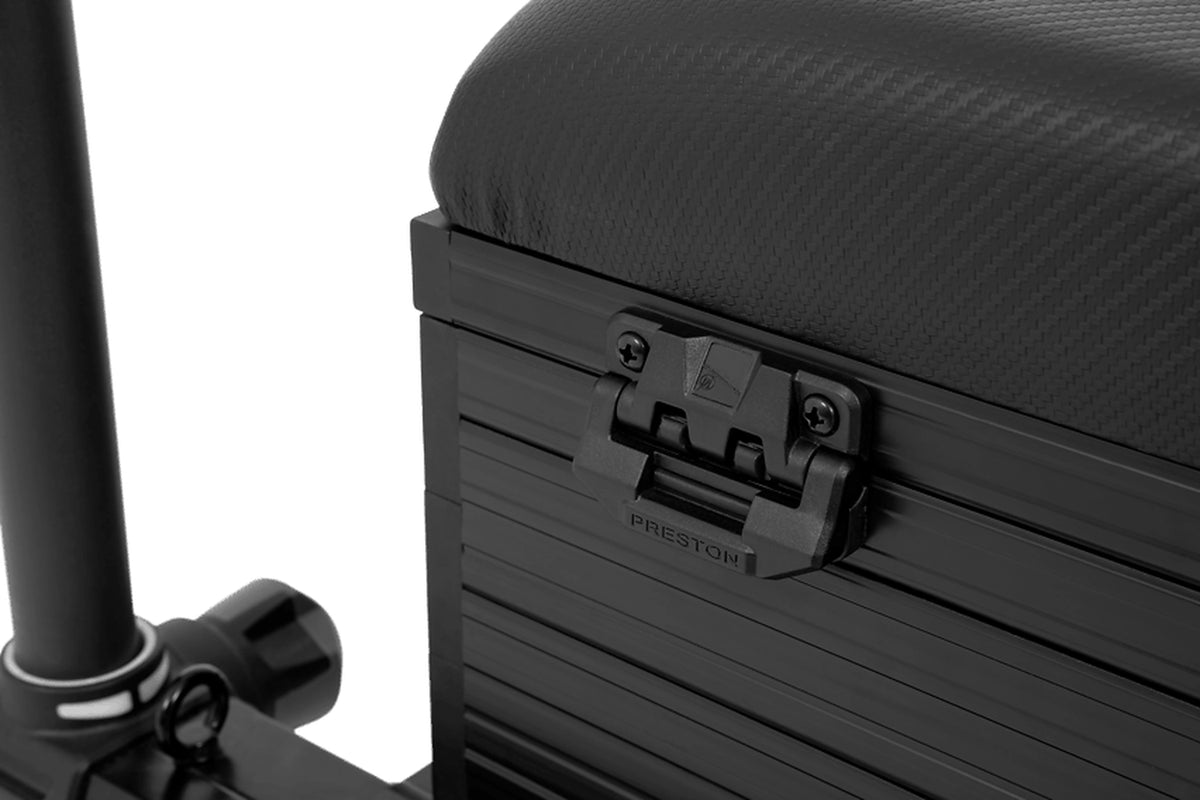 Preston Ignition SL Seatbox – detail van de zwarte Preston-sluitclip onder de gevoerde zitting en naast de pootklem