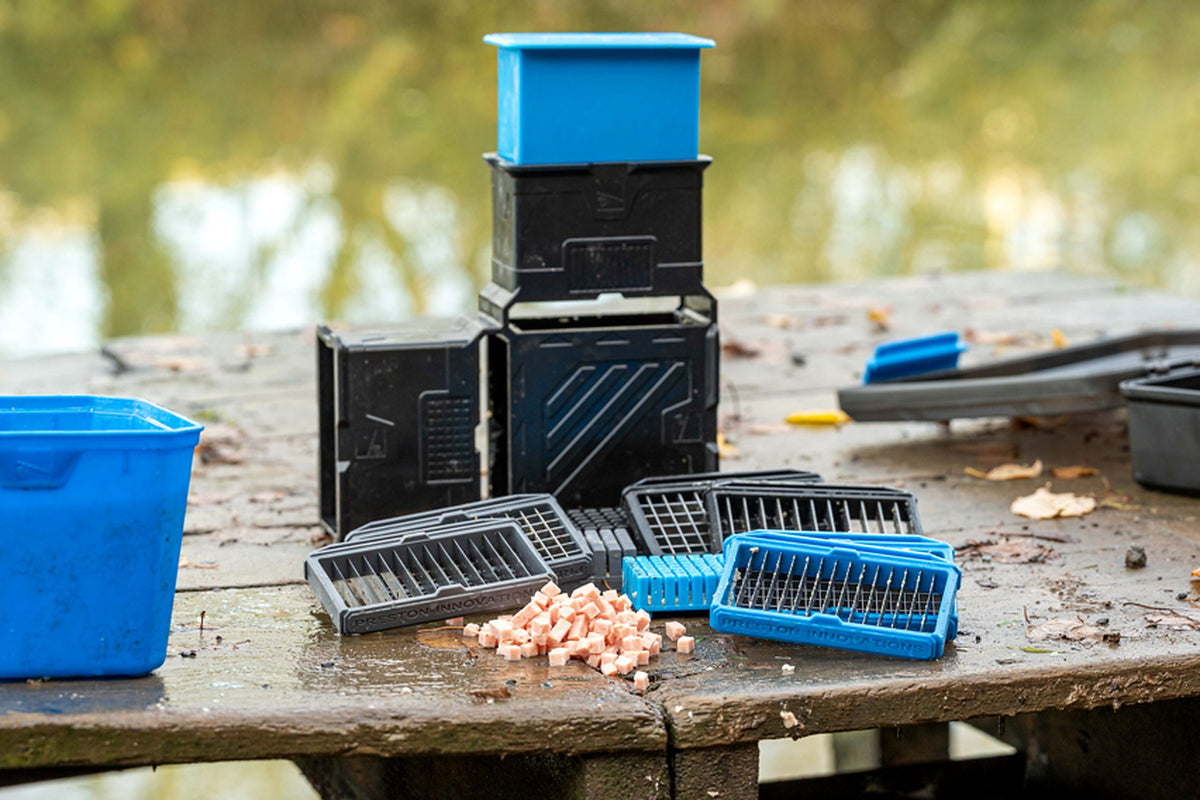 Preston Meat Cutter Set met blauwe en grijze snijrasters en gesneden vleesblokjes op een tafel aan het water