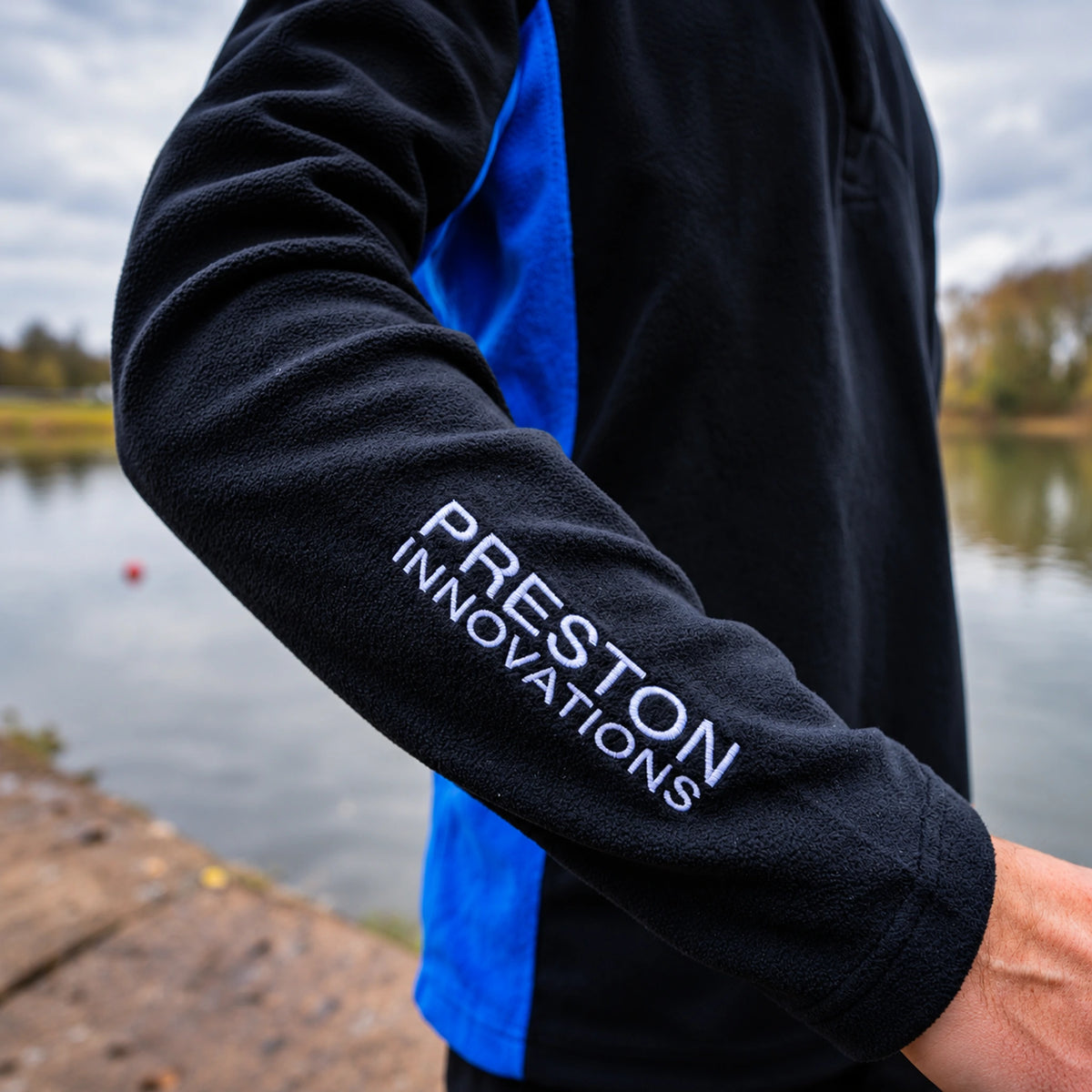 Preston Micro Fleece, detail van de gebogen mouw met witte Preston Innovations-borduring en manchet