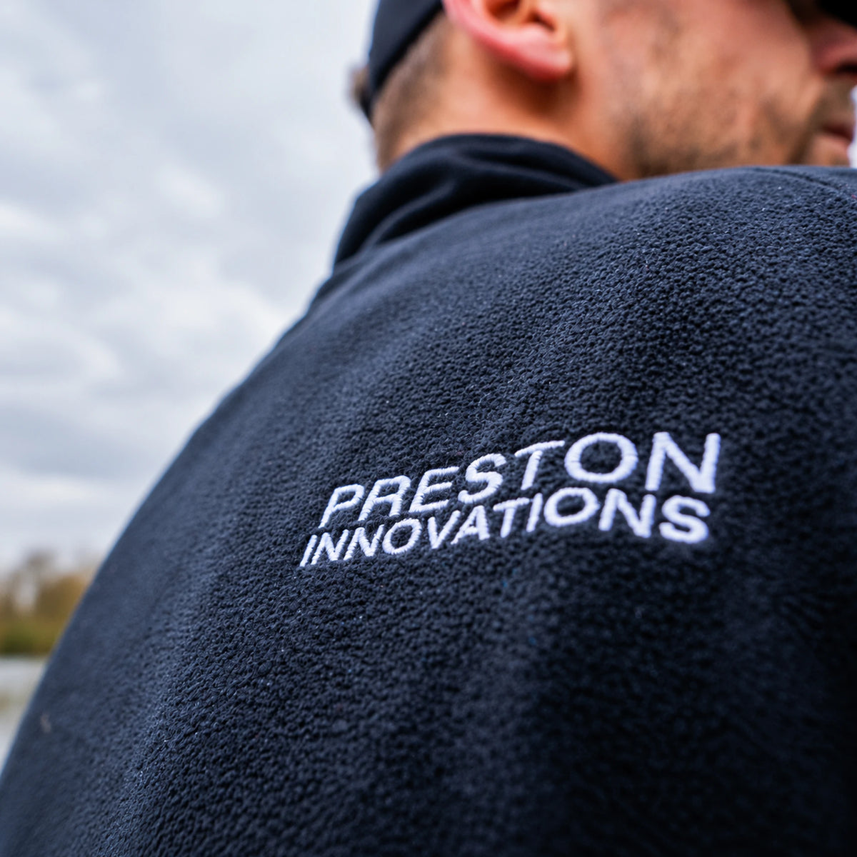Preston Micro Fleece, schouderclose-up van de witte Preston Innovations-rugborduring tijdens het dragen