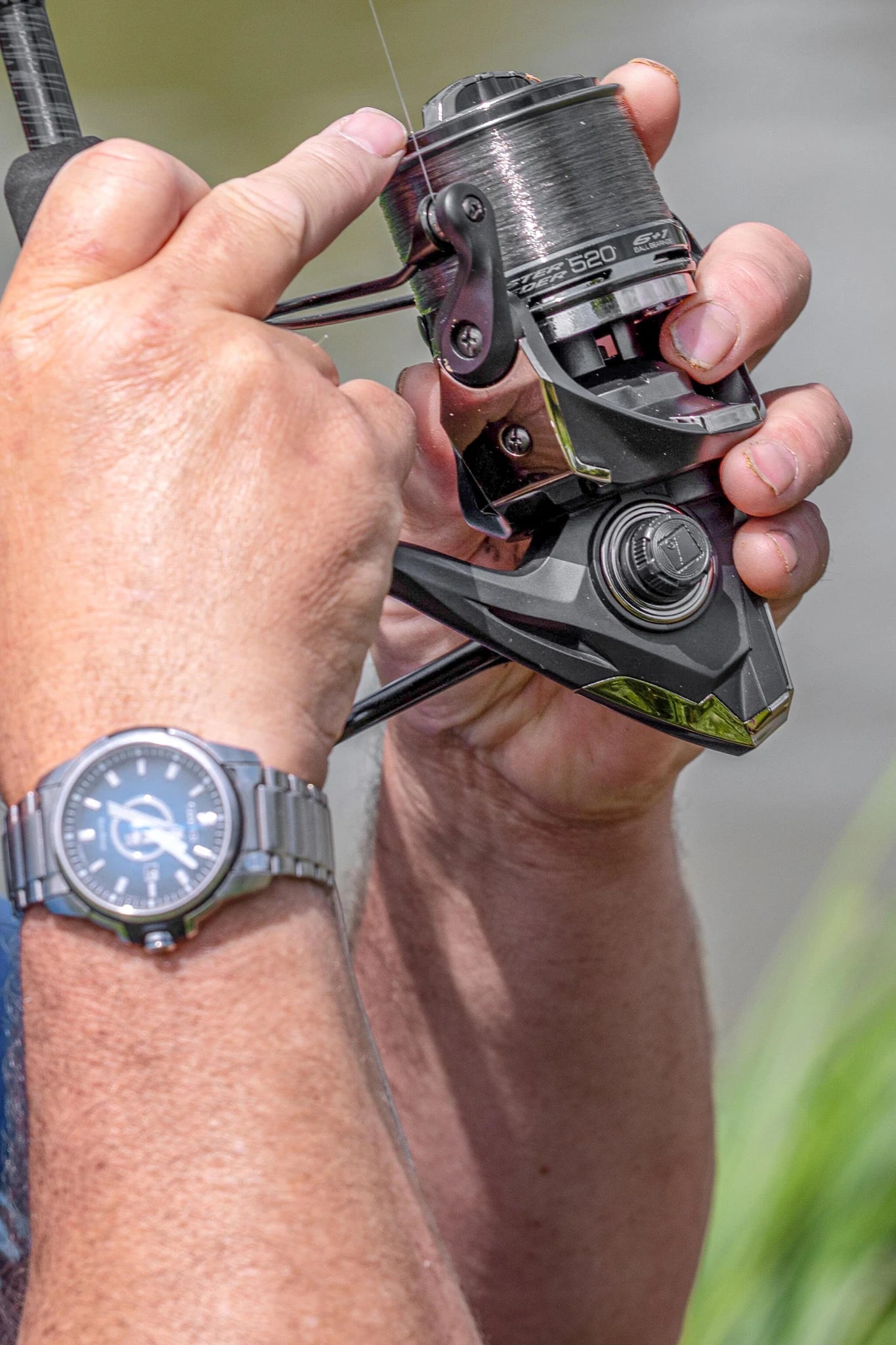 Preston Monster Feeder Reel in de hand van een visser