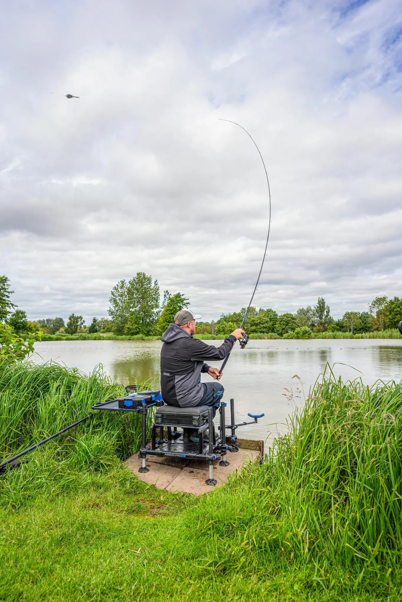 Preston Monster Xtreme Distance Feeder Rods - visser met gebogen hengel aan het water