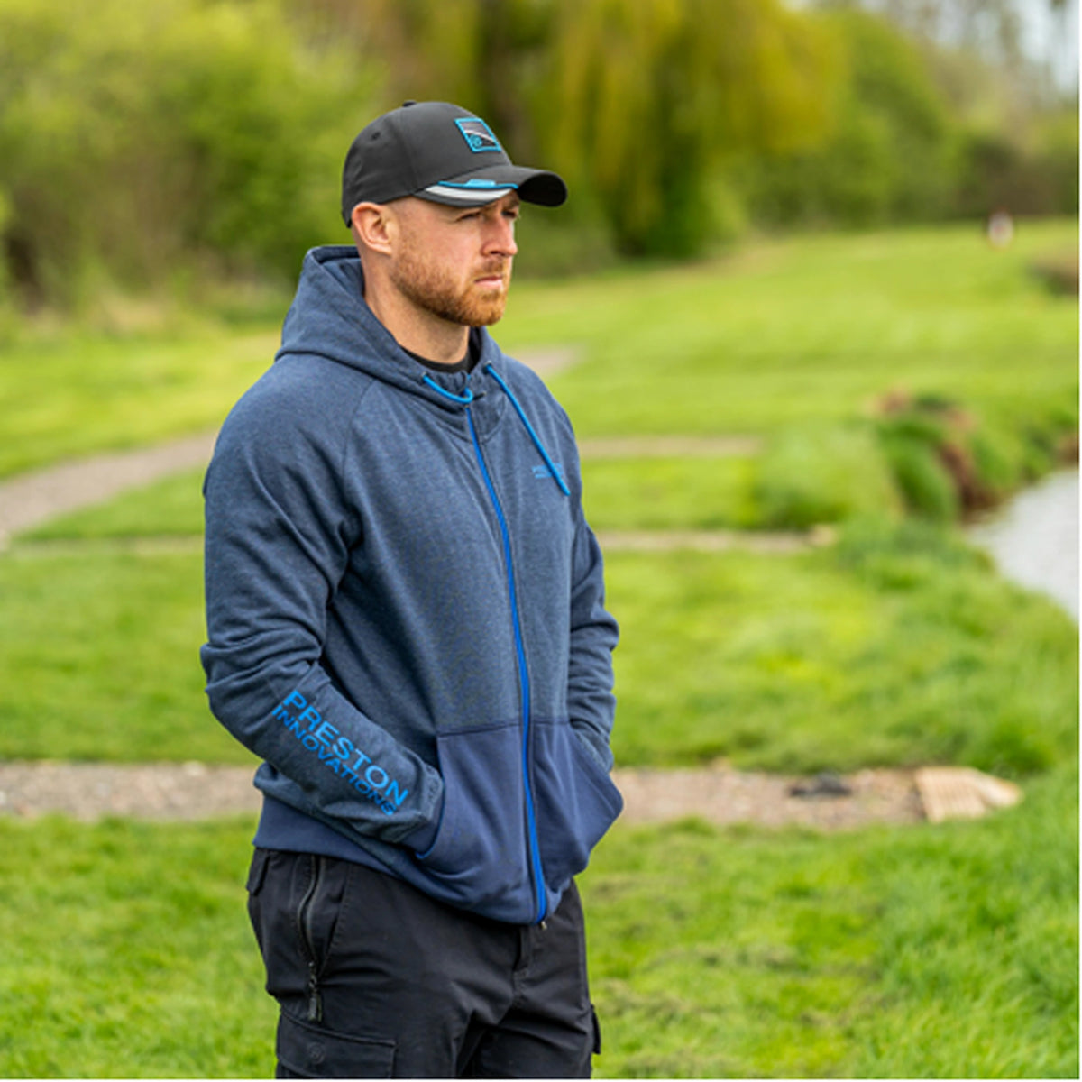 Preston Navy Tide Zip Hoodie – gedragen aan de waterkant met de handen in de buidelzakken