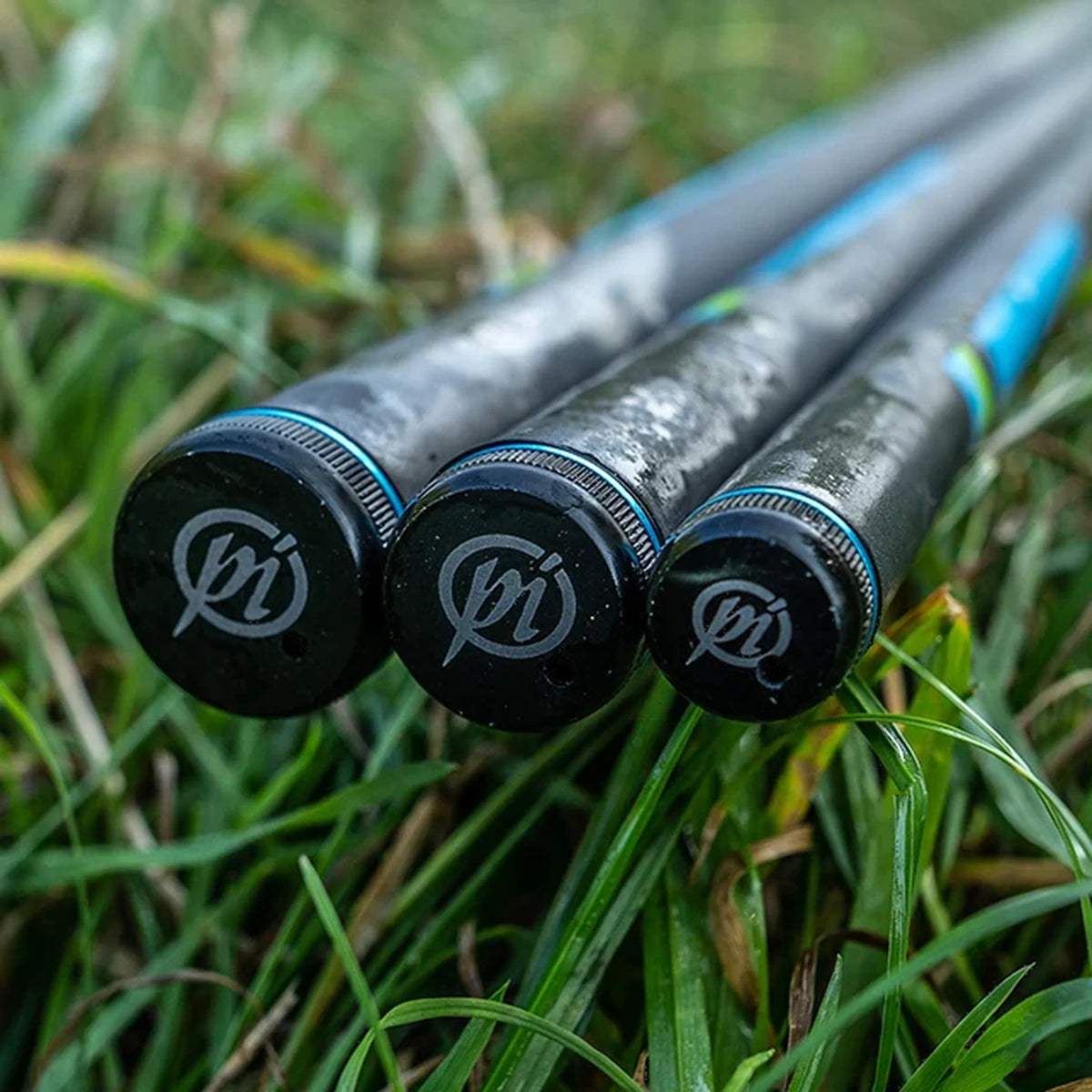 Detail van drie Preston Response Whips in het gras, met zwarte einddoppen, Preston-logo’s en blauwe randen