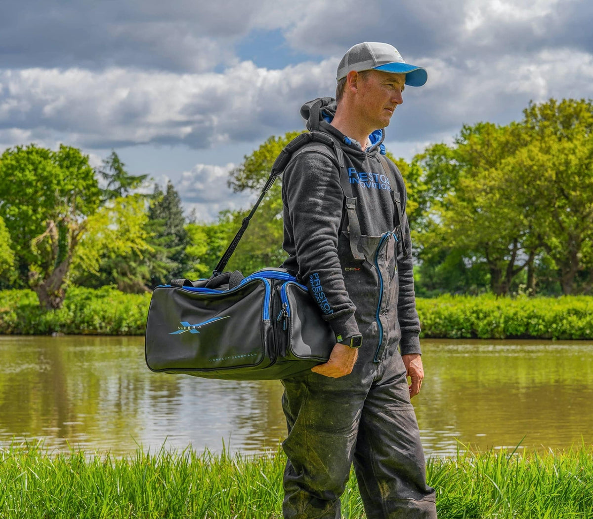 Visser draagt de Preston Supera X Compact Carryall aan de schouderriem bij de waterkant