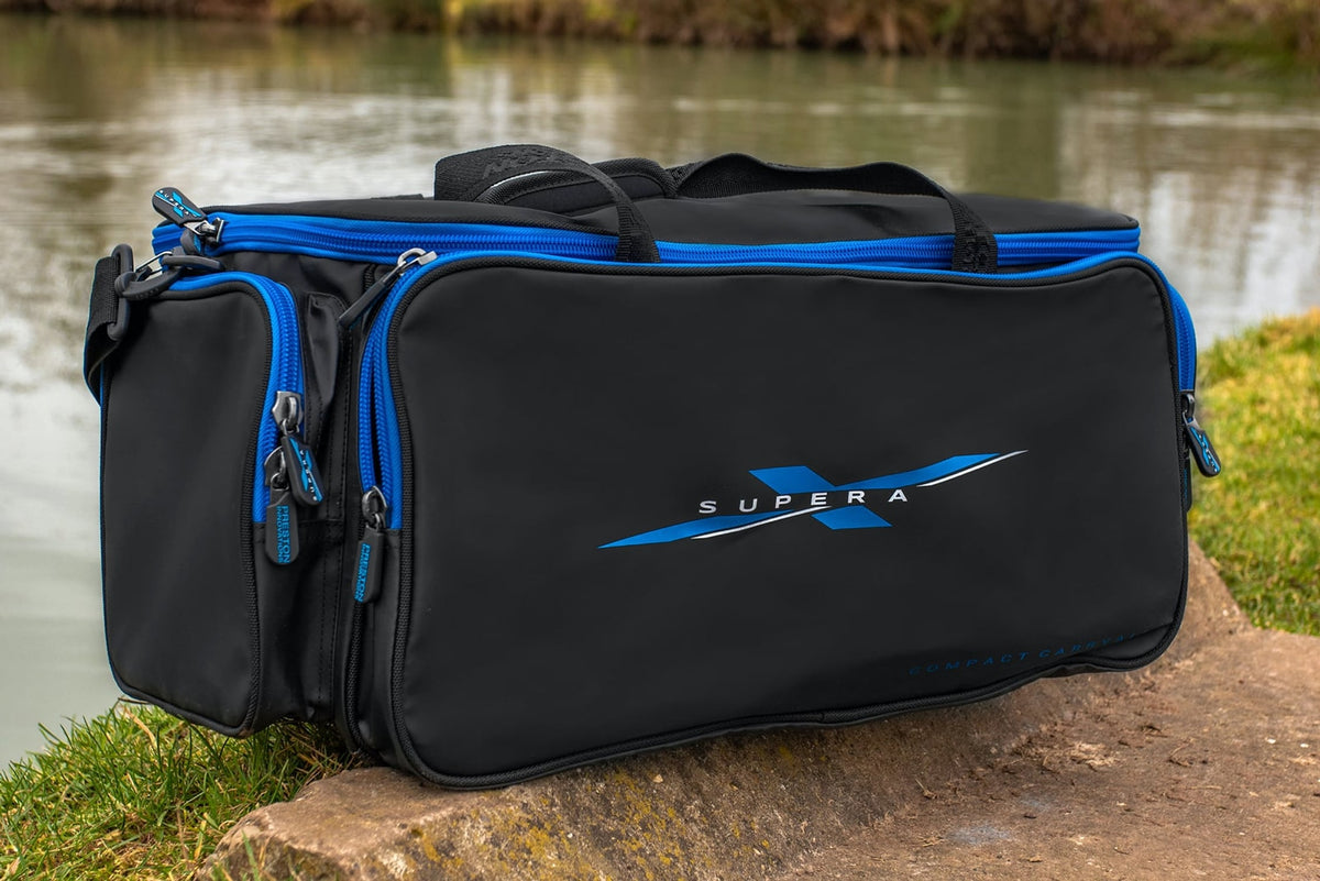 Preston Supera X Compact Carryall staat aan de waterkant, schuin van voren gezien