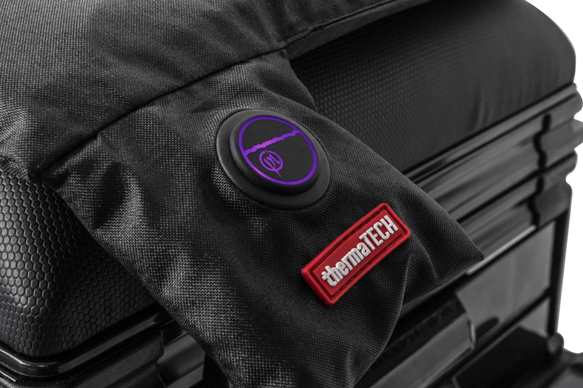 Preston ThermaTech verwarmd zitkussen – detail van de paars verlichte bedieningsknop en het rode ThermaTech-label