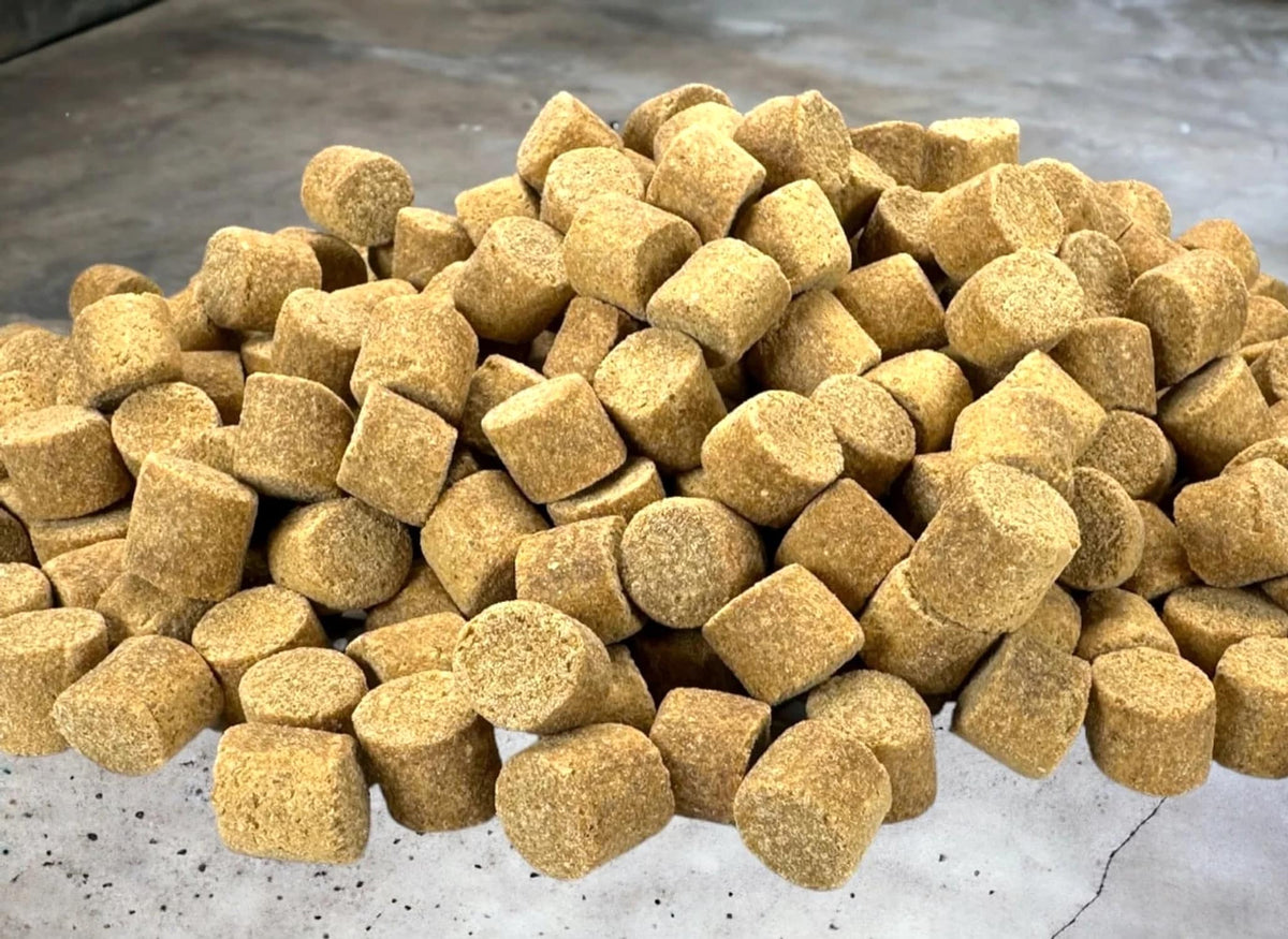 Grove Skretting Coarse Pellets op een grijze ondergrond, van dichtbij gefotografeerd