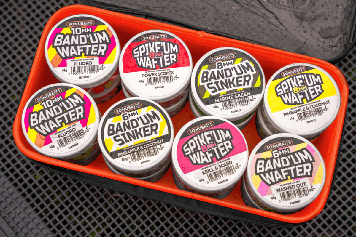 Sonubaits EVA Hookbait Storage Systems: open tas met verschillende haakaaspotjes op een aastafel