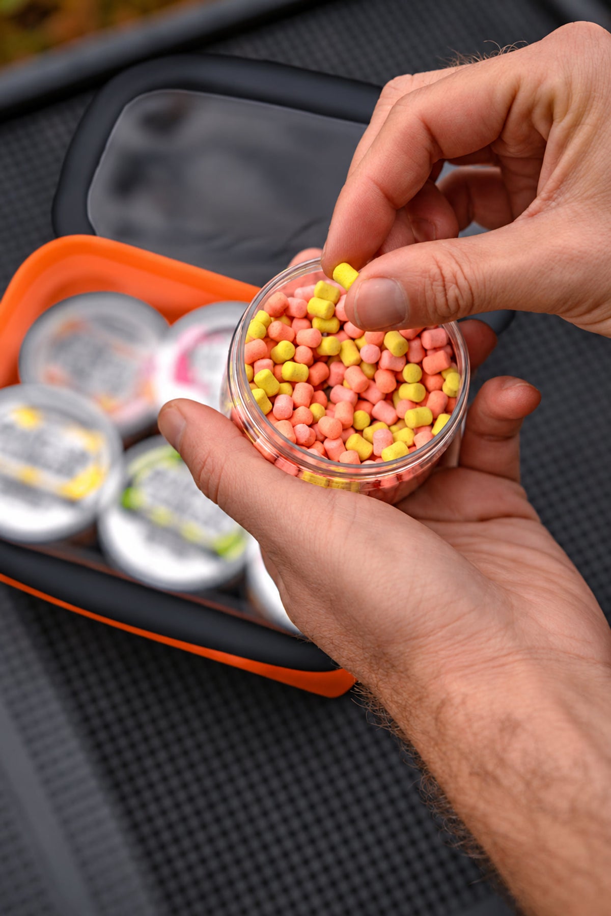 Sonubaits EVA Hookbait Storage Systems in gebruik: geel en roze haakaas uit een open potje pakken