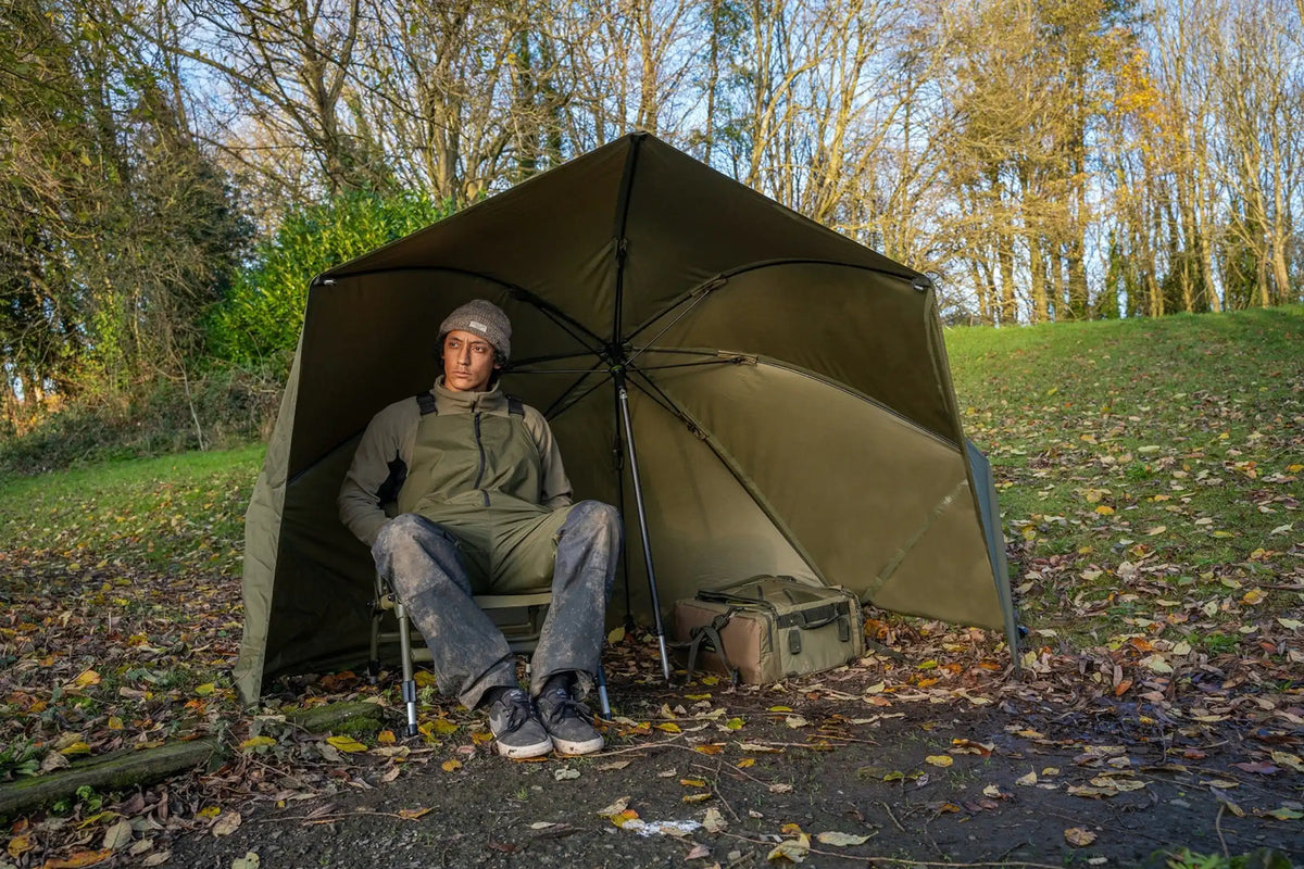 Korum Progress Graphite Brolly Shelter 50 inch – ruime beschutting met zijpanelen in buitensituatie