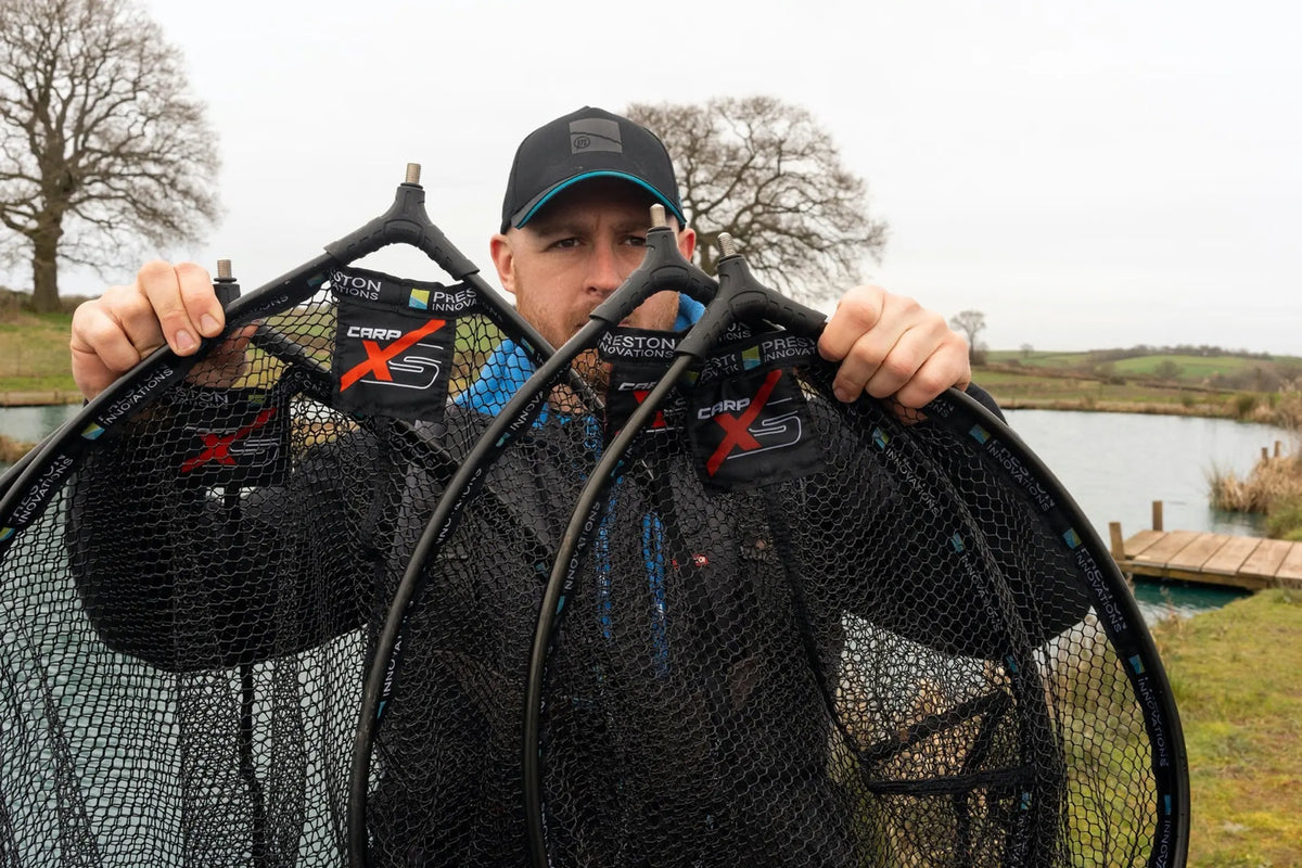 Preston Carp XS Landing Net Latex – visser toont vier schepnetten aan de waterkant