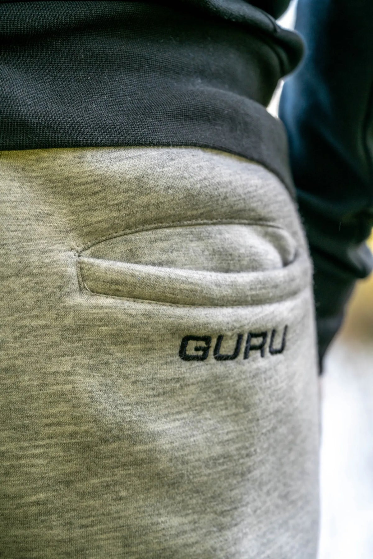 Guru Polar Joggers Grey – detail van achterzak met Guru-logo, gedragen