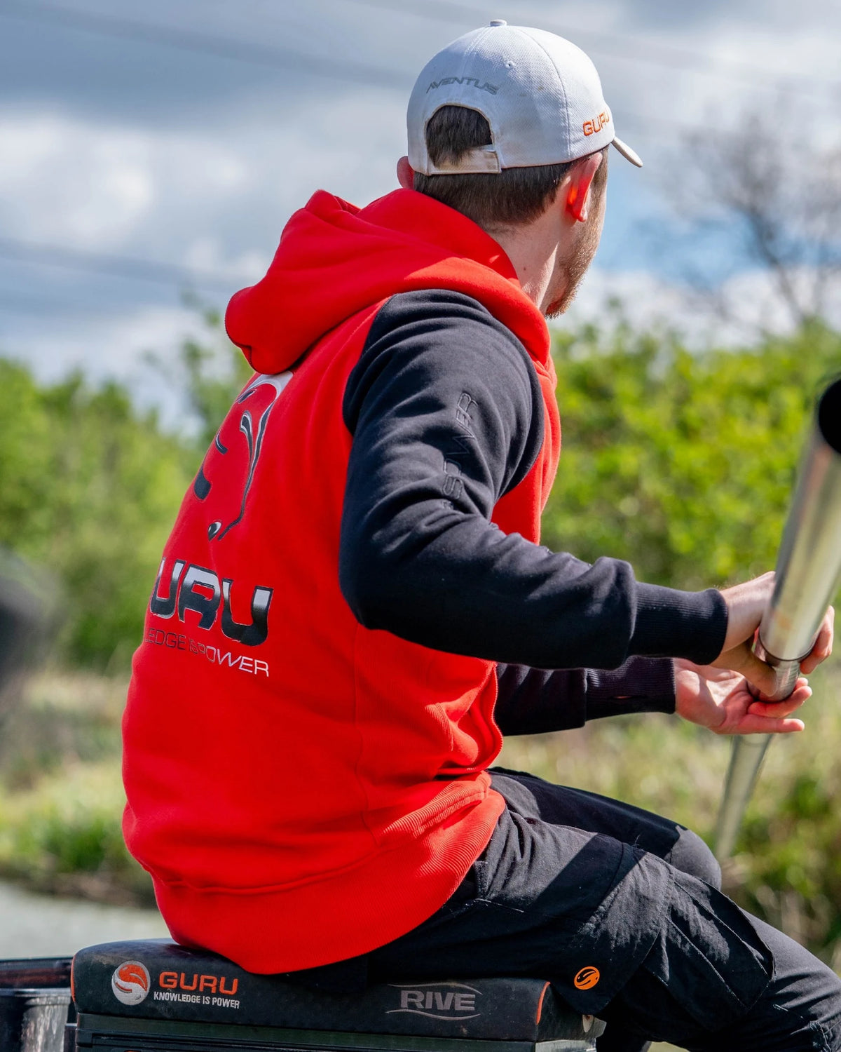 Guru Hoodie Red/Black, gedragen zijaanzicht met zwarte mouw en rode romp tijdens het vissen