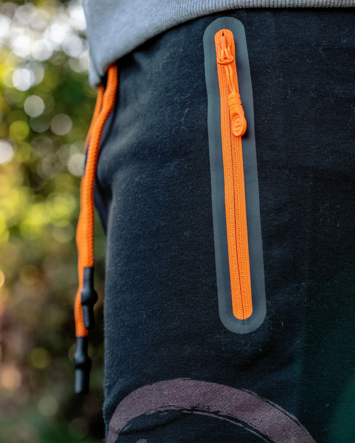Guru Jersey Shorts Black, close-up van de oranje zakrits en ritstrekker