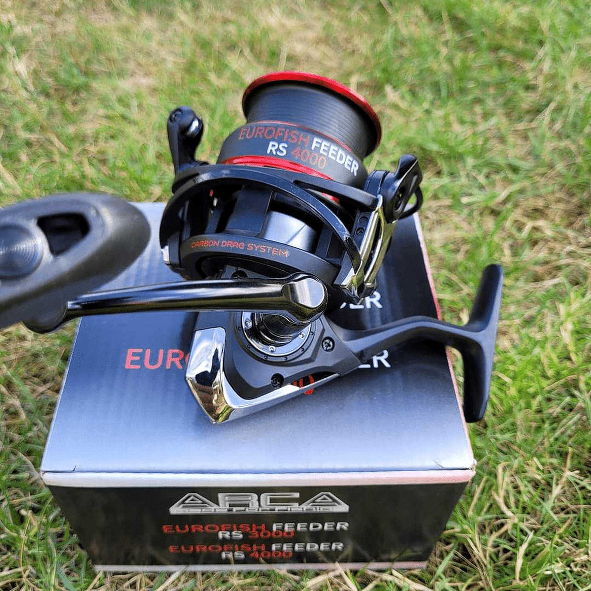 Arca Eurofish Feeder RS molen op de productverpakking in het gras, met zicht op spoel en slinger