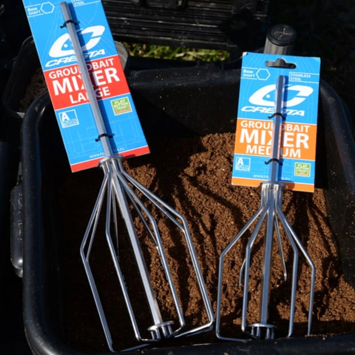 Cresta Baitmixer – Medium en Large in hun originele verpakking bij een teil grondvoer