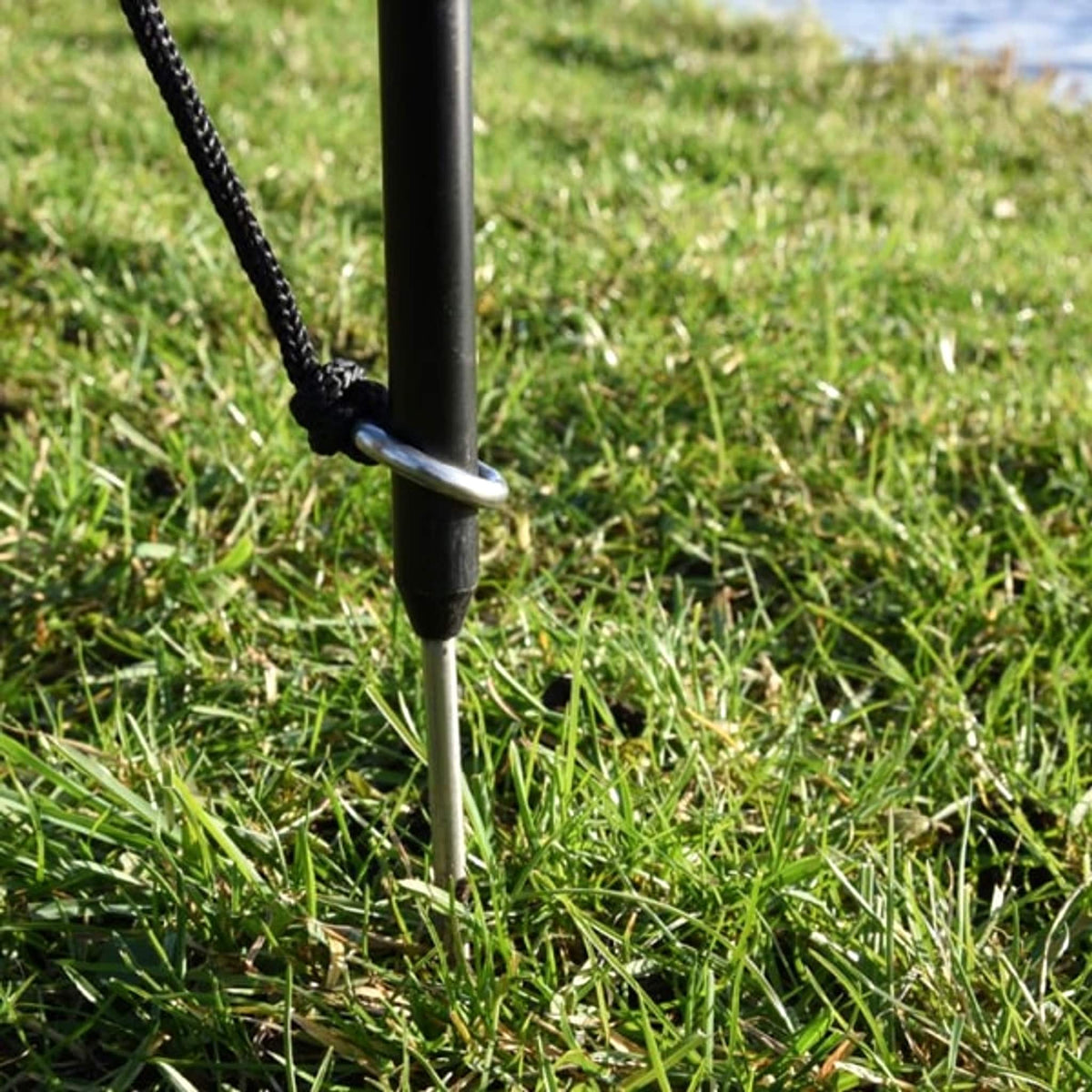 Metalen koordring rond een Cresta-afstandsstok die in het gras is geplaatst