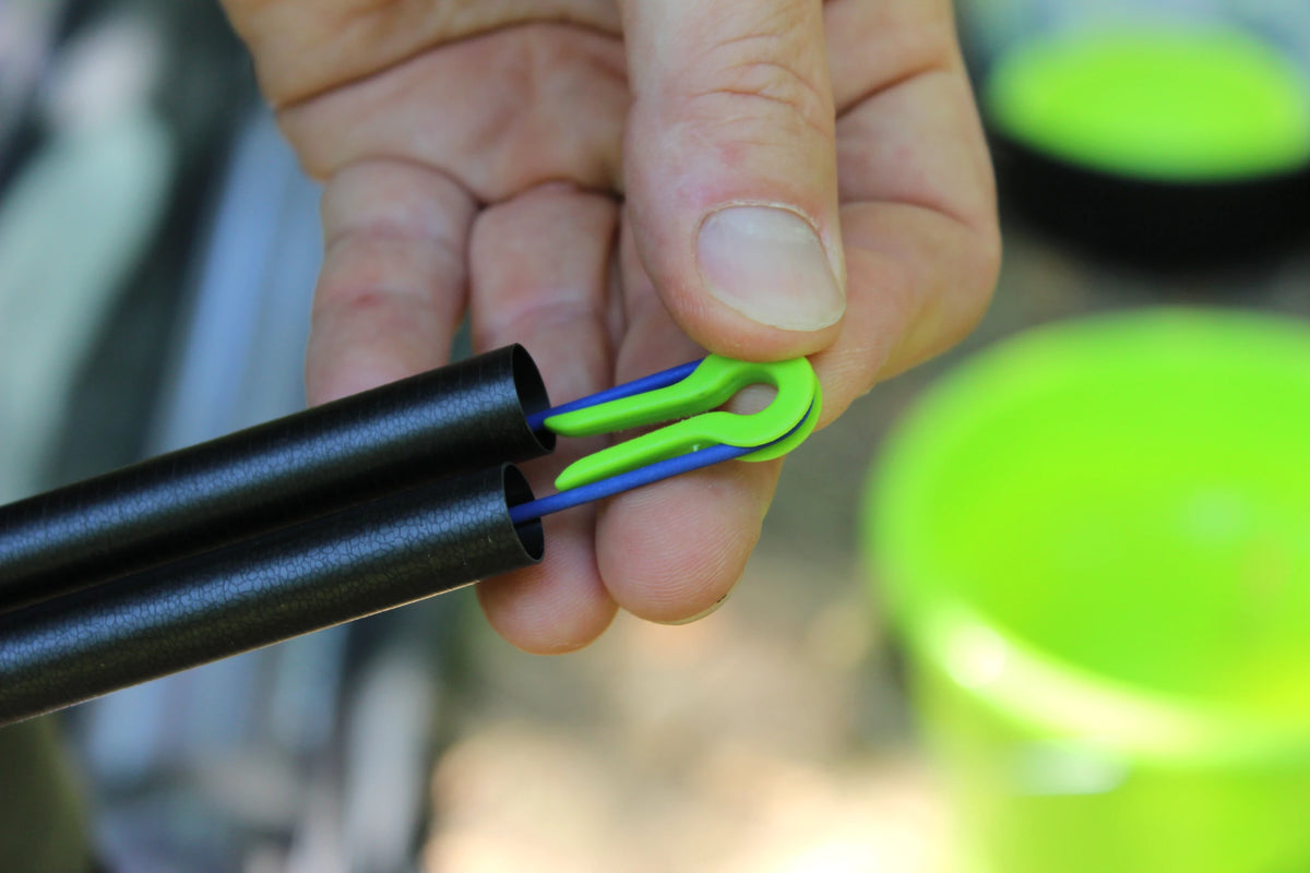 Fun Fishing Elastic Protector met blauw elastiek tussen twee hengeldelen, vastgehouden in de hand