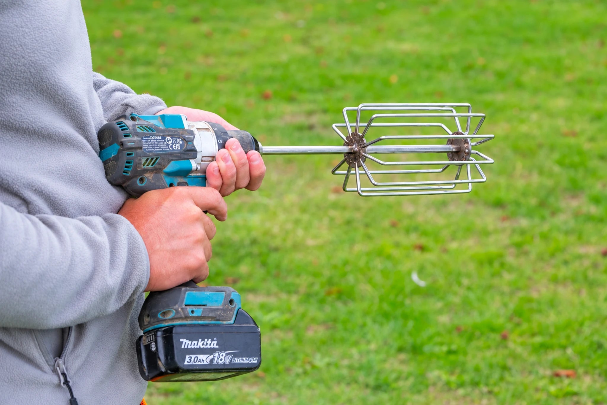 Guru Ground Bait Whisk gemonteerd op een boormachine, klaar om grondvoer te mengen