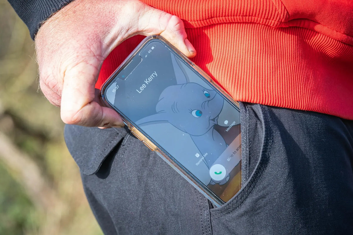 Guru Match Kombats - telefoon in de ritszak van de broek
