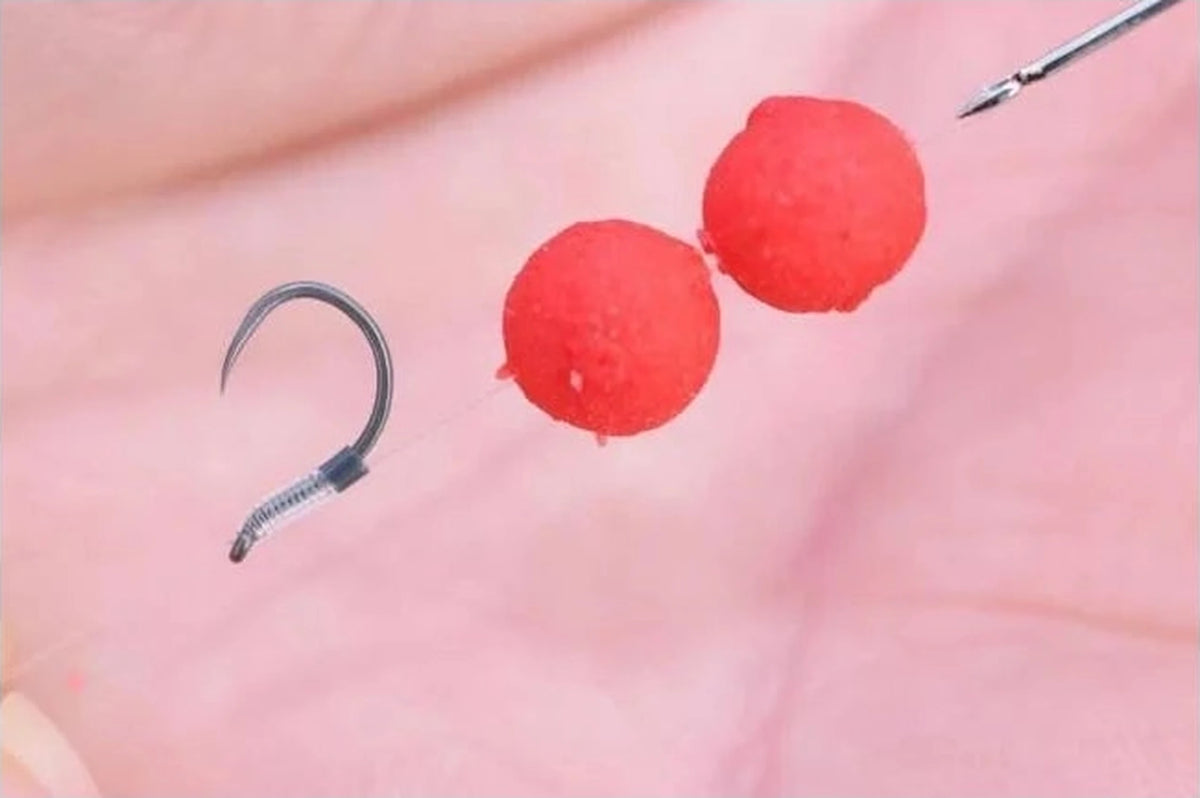 Guru QM1 Barbless-haak tijdens het bevestigen van rode boilies