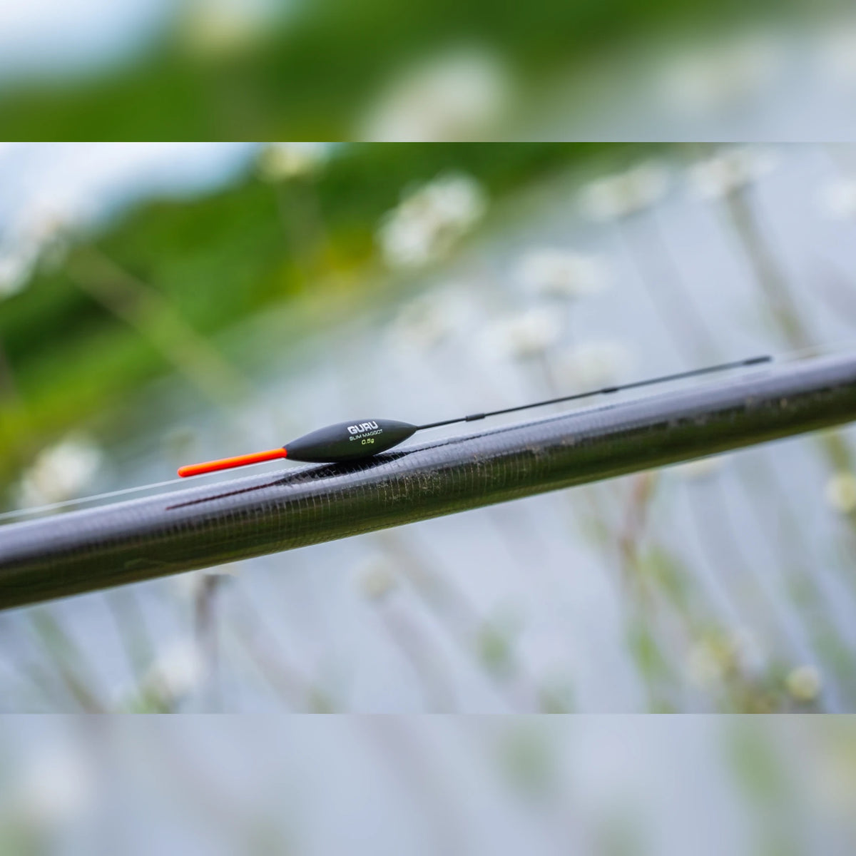 Guru Slim Maggot 0.5g dobber met oranje antenne aan een hengel