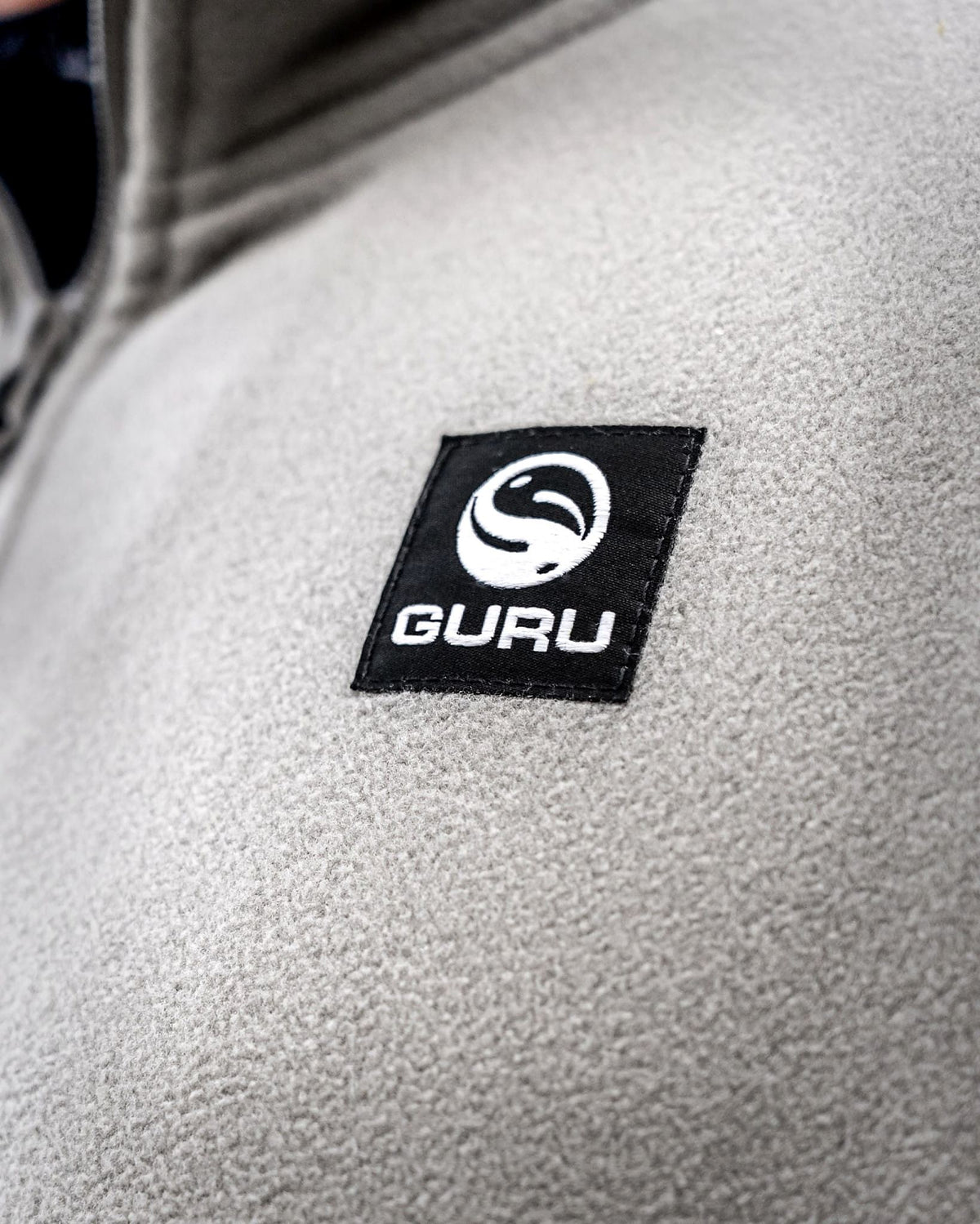 Guru Zip Fleece Grey – Guru-borstbadge op de grijze fleecestof