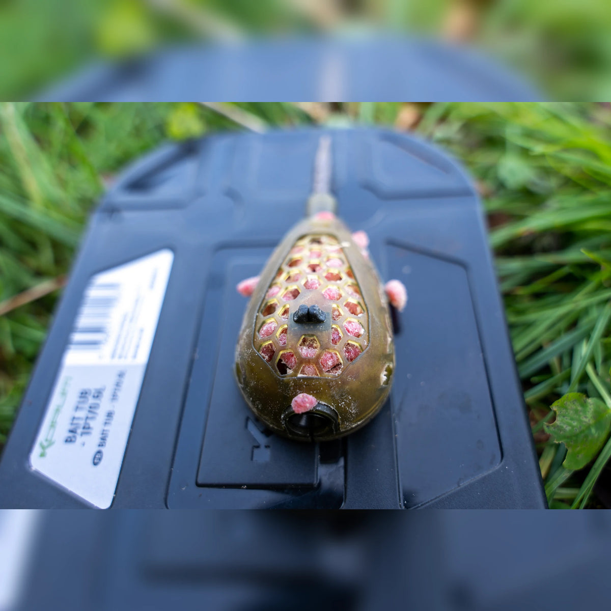 Korum Camo Grub Feeder – madenkorf gevuld op een aasdoos