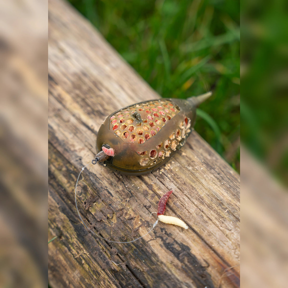 Korum Camo Grub Feeder – gevulde Large-korf op een houten rand