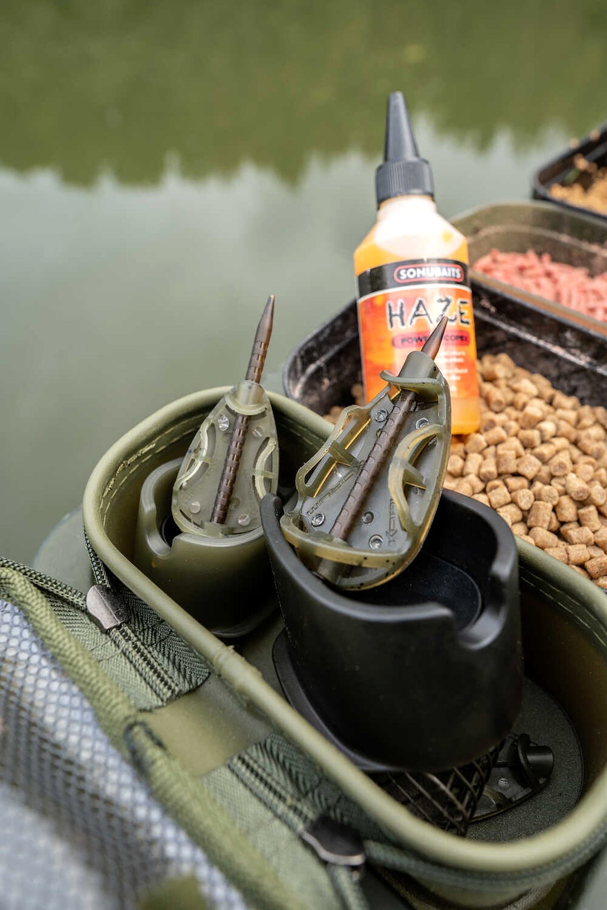 Korum Camo Method Feeders met methodmallen en pellets op een aastas aan de waterkant