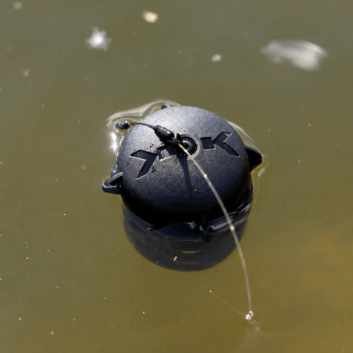 Korum Floating Feeder K0320069 met donkere kap drijvend aan het wateroppervlak
