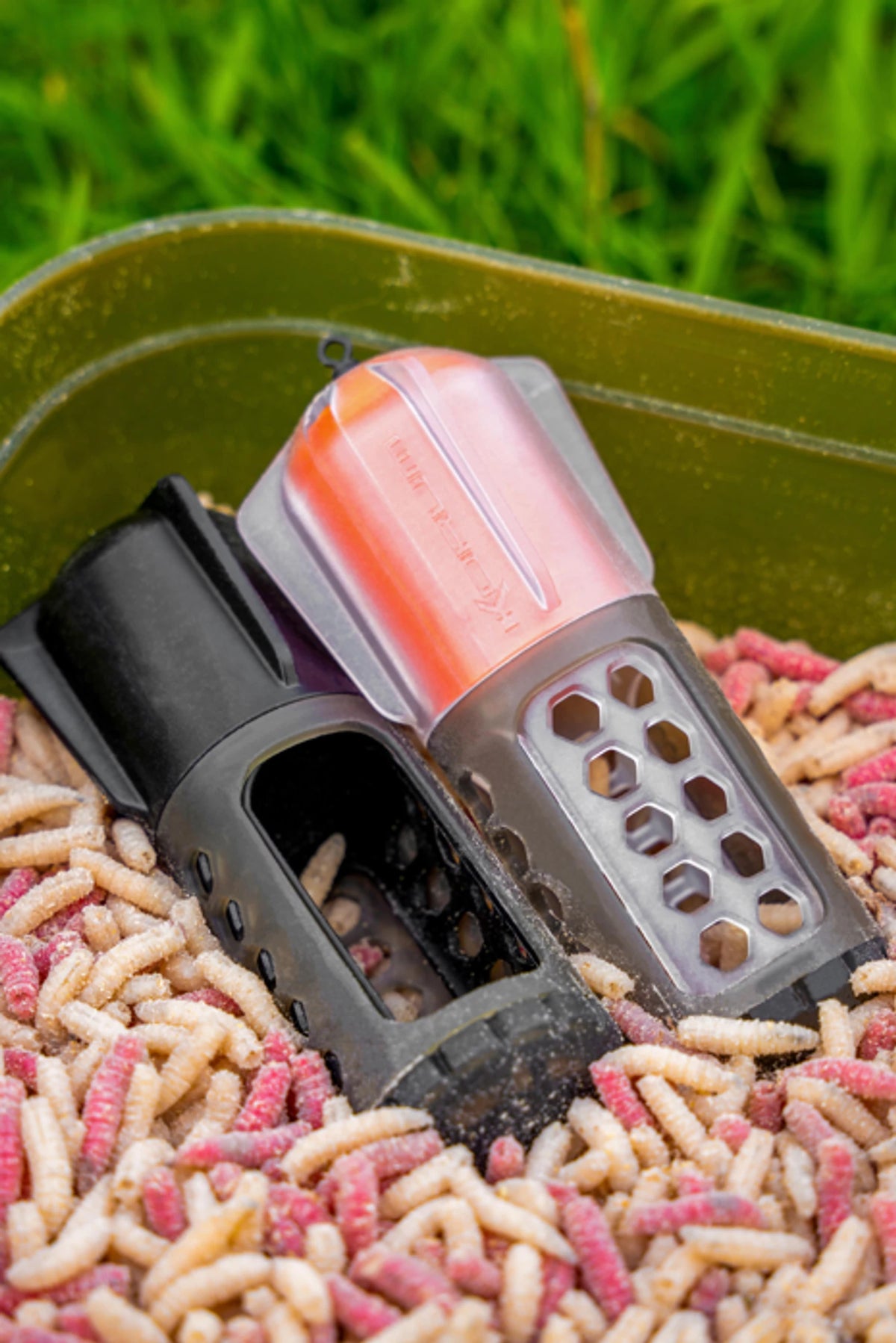 Korum Floating Window Combi Feeder Black Top en Fluoro Top met open voervenster in een bak maden