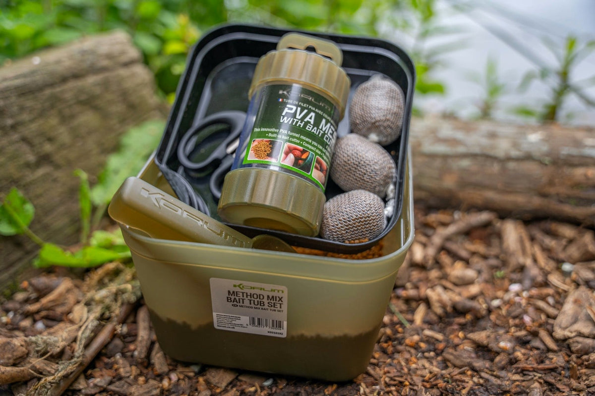 Korum Method Mix aasbak met binnentray boven de pellets, gevuld met PVA-koker, schaar en aaszakjes