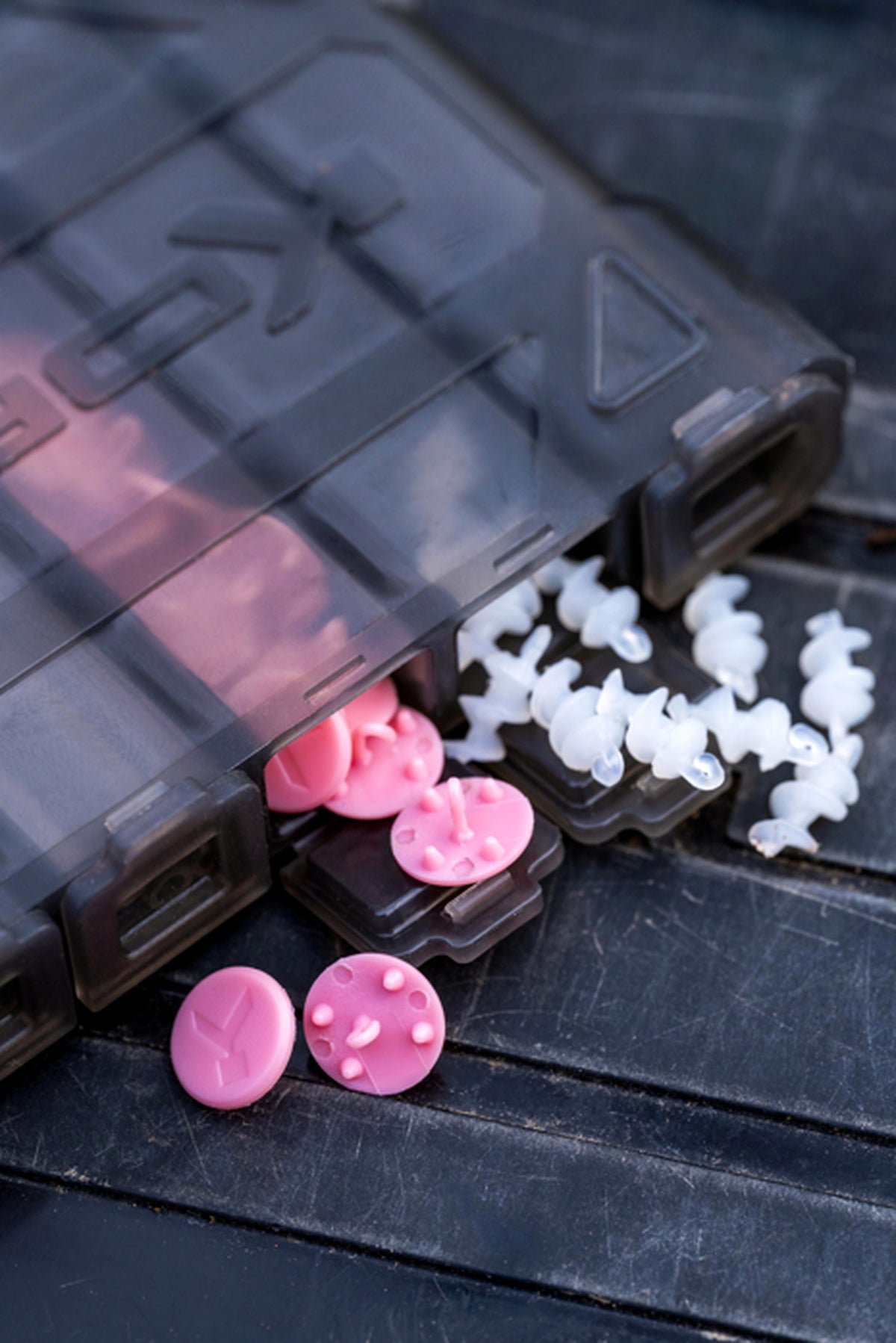 Detail van geopende doppen van de Korum Tackle Dispenser Blox met roze en wit kleinmateriaal