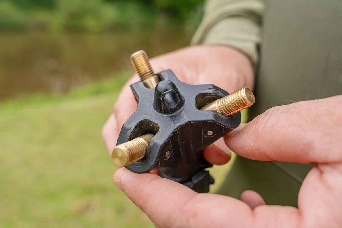 Onderzijde van de Korum Tripod Adaptor Block met drie messing schroefdraden en centraal ophangoog