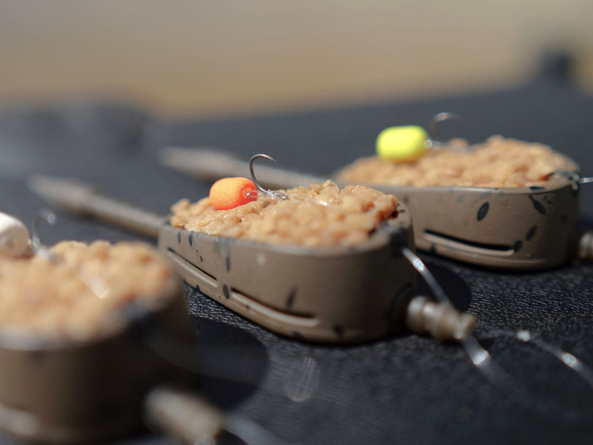 MAP Embed Feeders Inline – close-up van een met pellets gevulde methodfeeder met oranje haakaas en haak