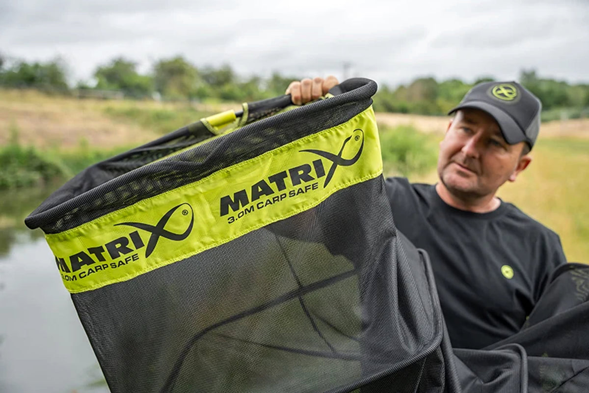 Visser toont de opening van het Matrix Carp Safe Keepnet met de originele 3.0M Carp Safe-merkband