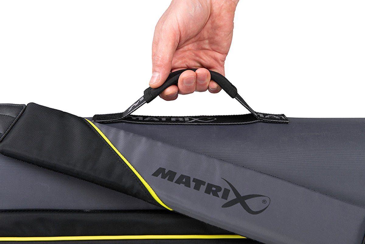 Matrix Ethos Rigid Holdall – hand om de zwarte draaghandgreep naast de gevoerde Matrix-schouderriem