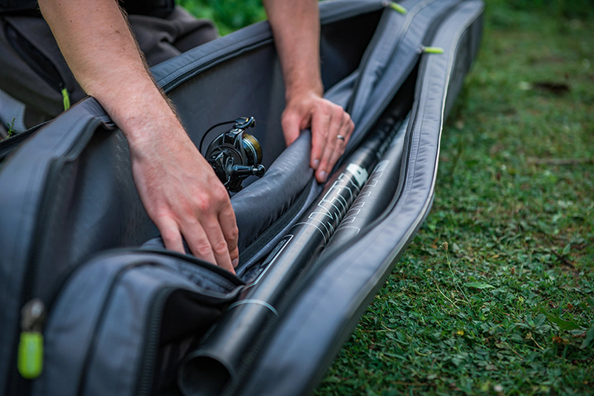 Matrix Ethos Rigid Holdall – hengels en molen in de geopende gevoerde vakken met tussenschot tijdens gebruik op het gras