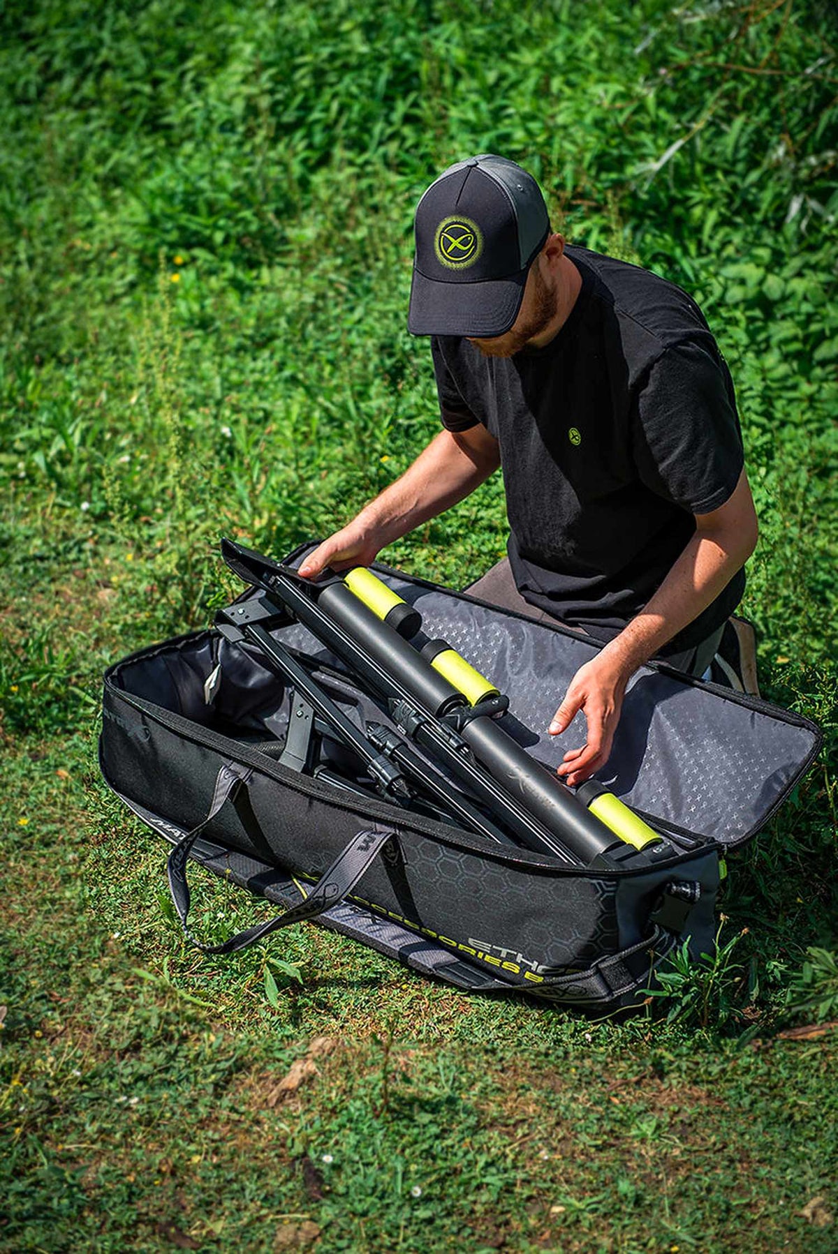 Matrix Ethos XL Accessories Bag – visser pakt een afsteekroller in de geopende tas, verticaal overzicht