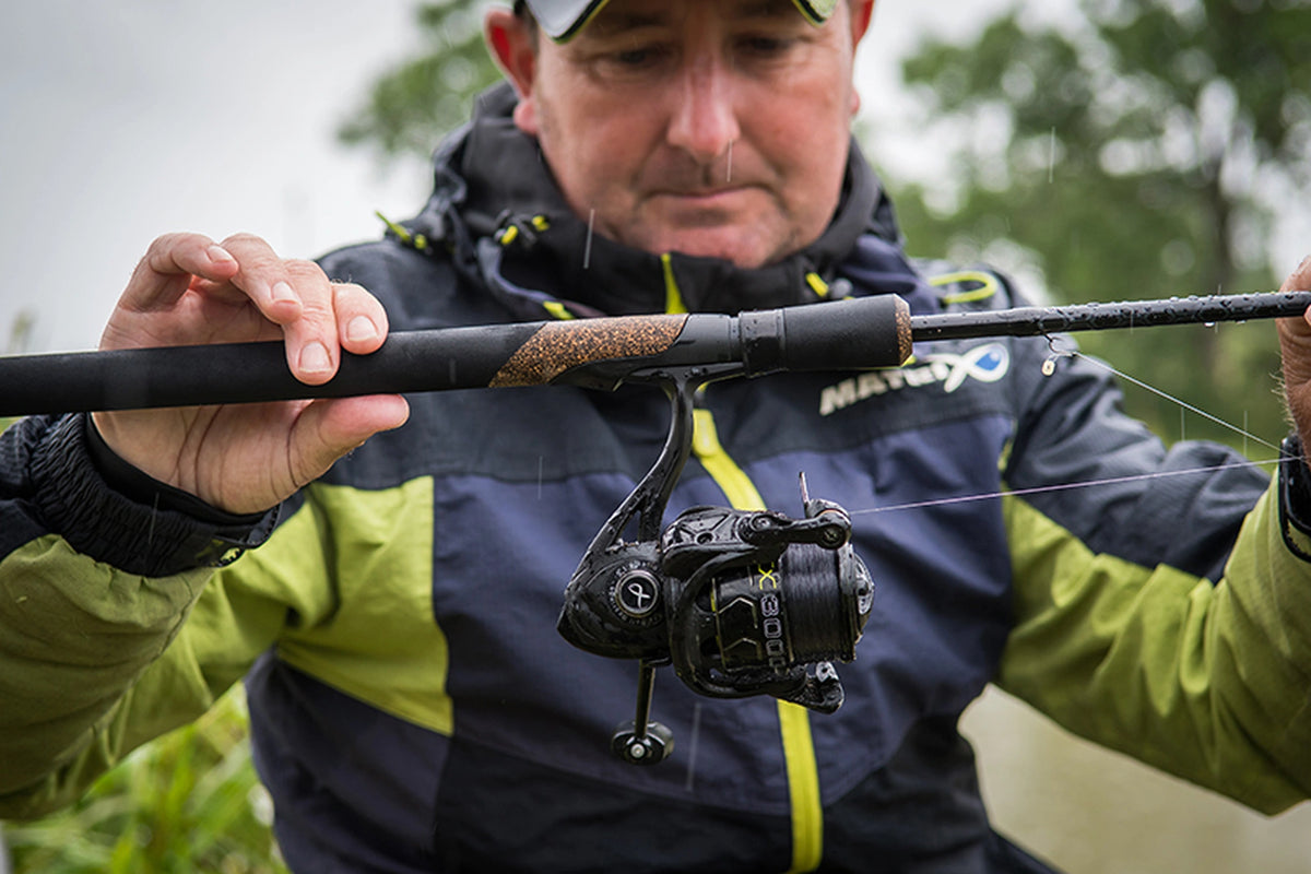 Matrix Ethos XR-C Bomb Rod 9ft – visser toont de handgreep en molenhouder van de hengel met een gemonteerde molen