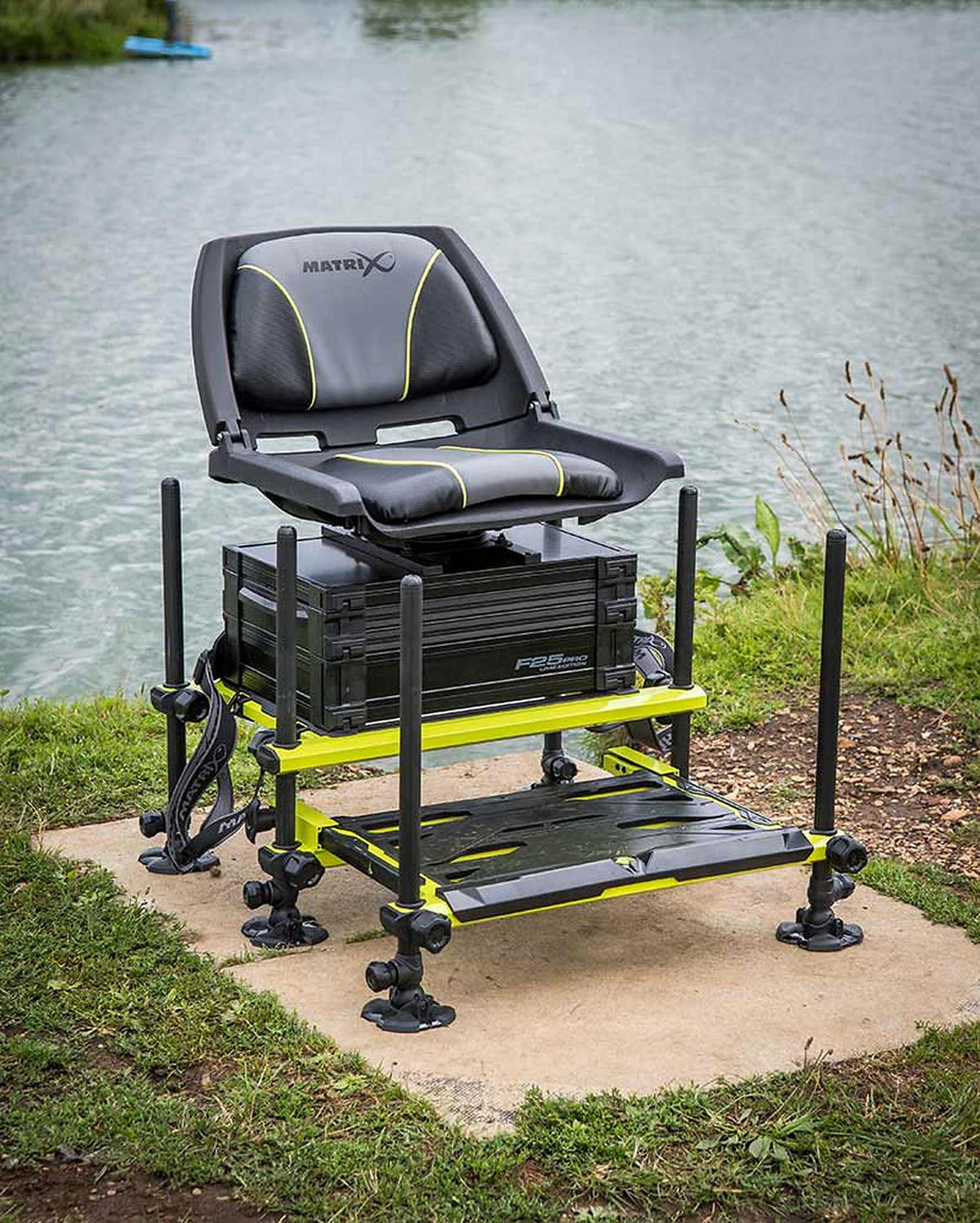 Matrix F25 Pro Swivel Seatbox Lime Edition met schuin zijaanzicht van de zitkist aan het water