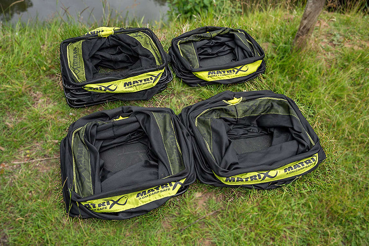 Matrix Flow Mesh Keepnet 4m – groepsfoto van vier opgevouwen Matrix-leefnetten op het gras aan de waterkant