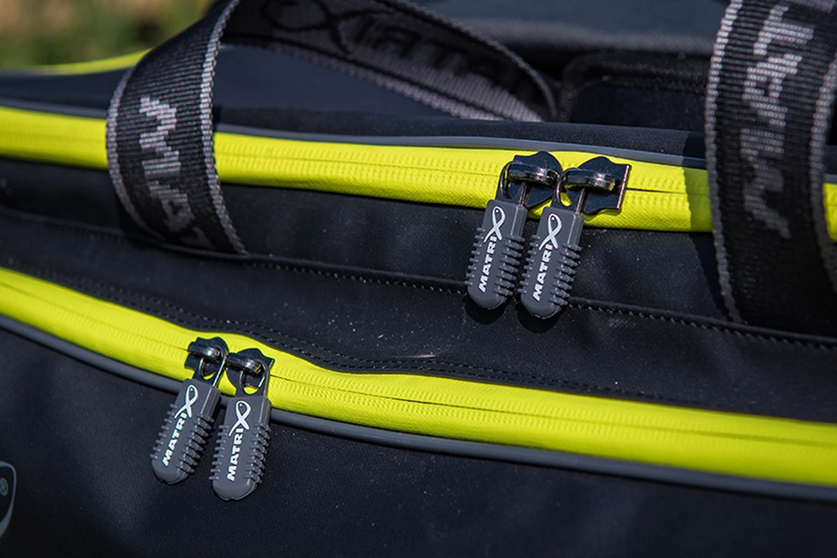 Matrix Horizon X Compact Carryall – buitendetail van de gele ritsen en vier Matrix-ritstrekkers