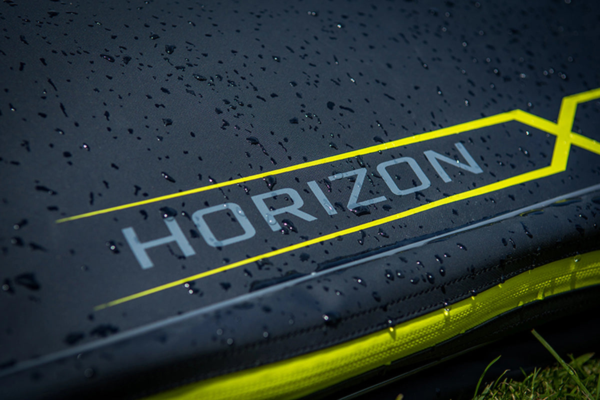 Matrix Horizon X XL Rigid Rod Holdall 3-6 – waterdruppels op de zwarte stof naast de Horizon X-opdruk en gele rits