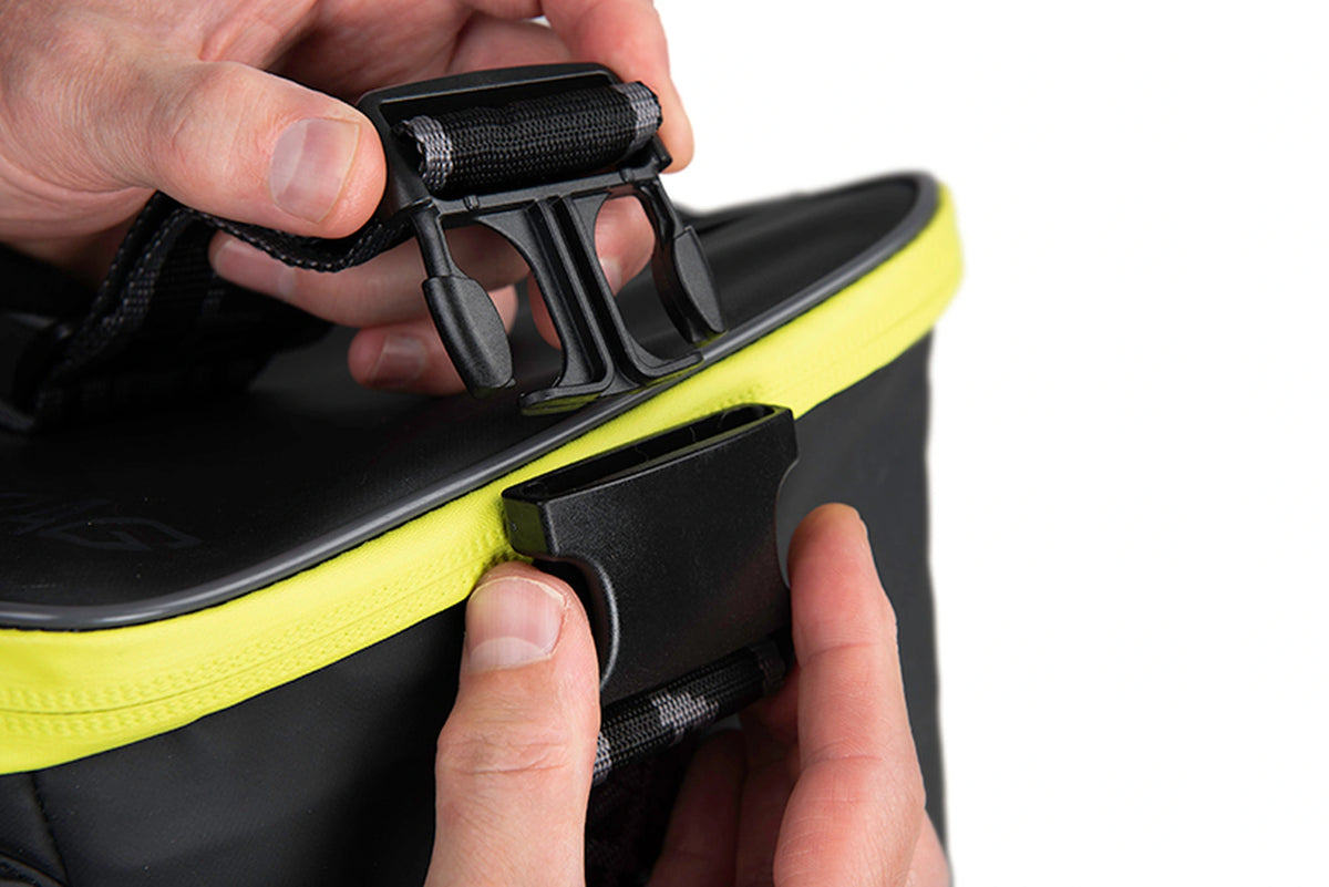 Matrix Horizon X XXL Storage Bag – twee handen tonen de geopende klikgesp van de afneembare schouderriem
