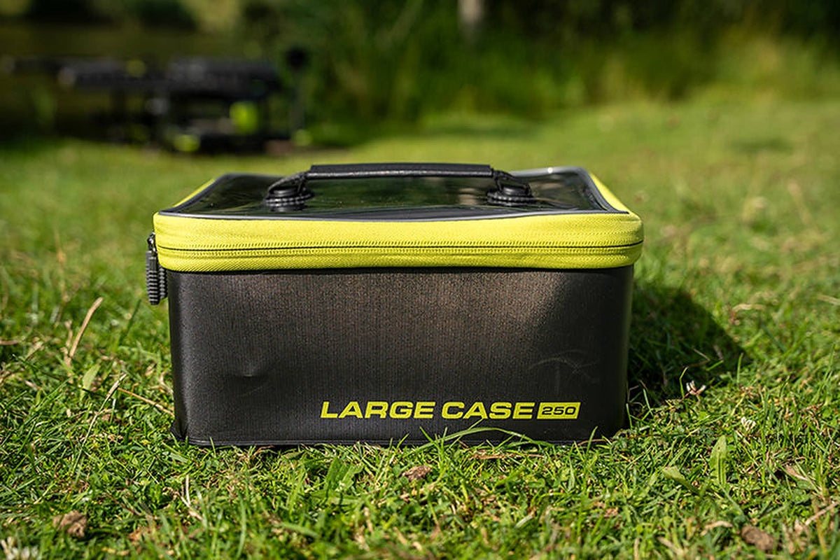 Matrix Large EVA Case 250 – vooraanzicht van de gesloten zwarte case met gele rits en draaggreep op het gras