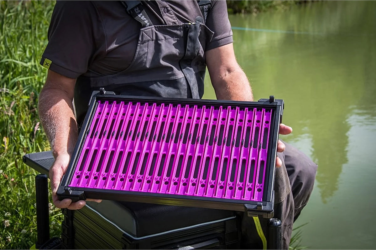 Matrix Pole Winders Loaded Tray – zittende visser toont de complete paarse lade met zwart buitenframe aan de waterkant