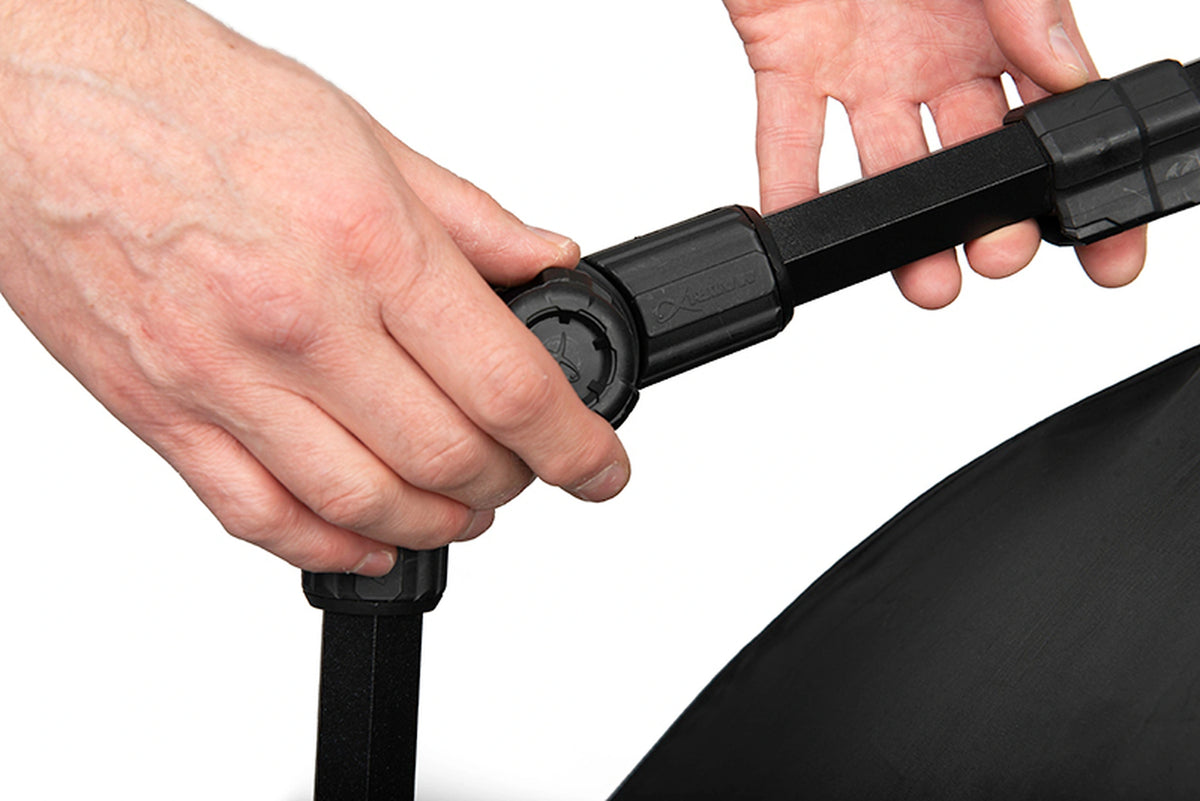 Matrix Pro Bait Brolly – handen bedienen het ronde scharnier om de hoek van de zwarte steunarm te verstellen